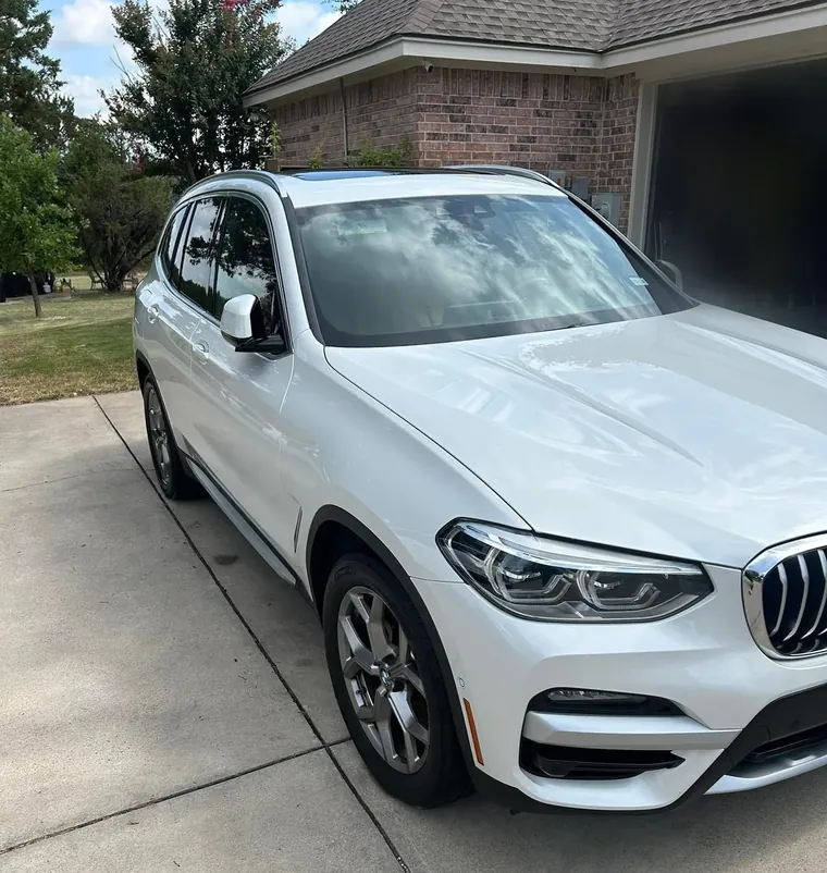 White BMW X3 washed and finished in a driveway