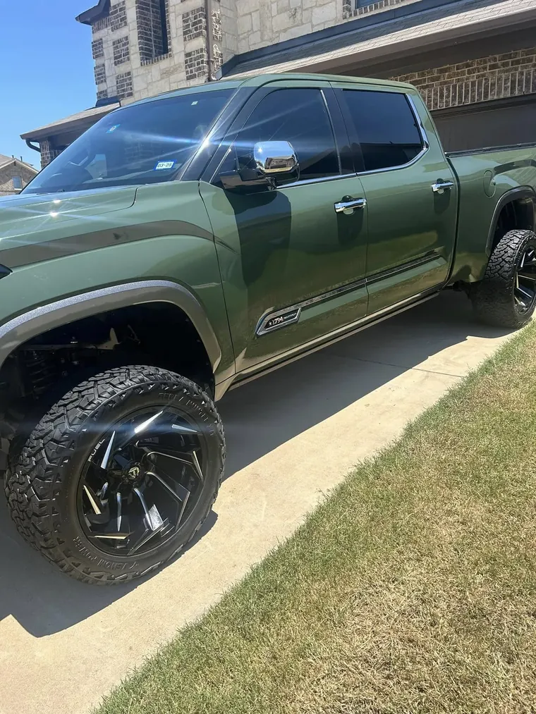Lifted green Toyota Tundra, side view